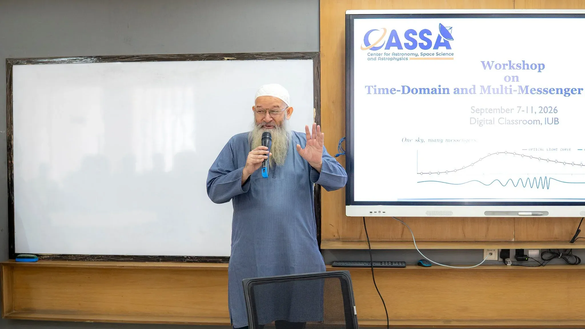 Dr. Habib Bin Muzaffar, Dean of the School of Engineering, Technology and Sciences, speaks with a microphone beside the workshop title slide.