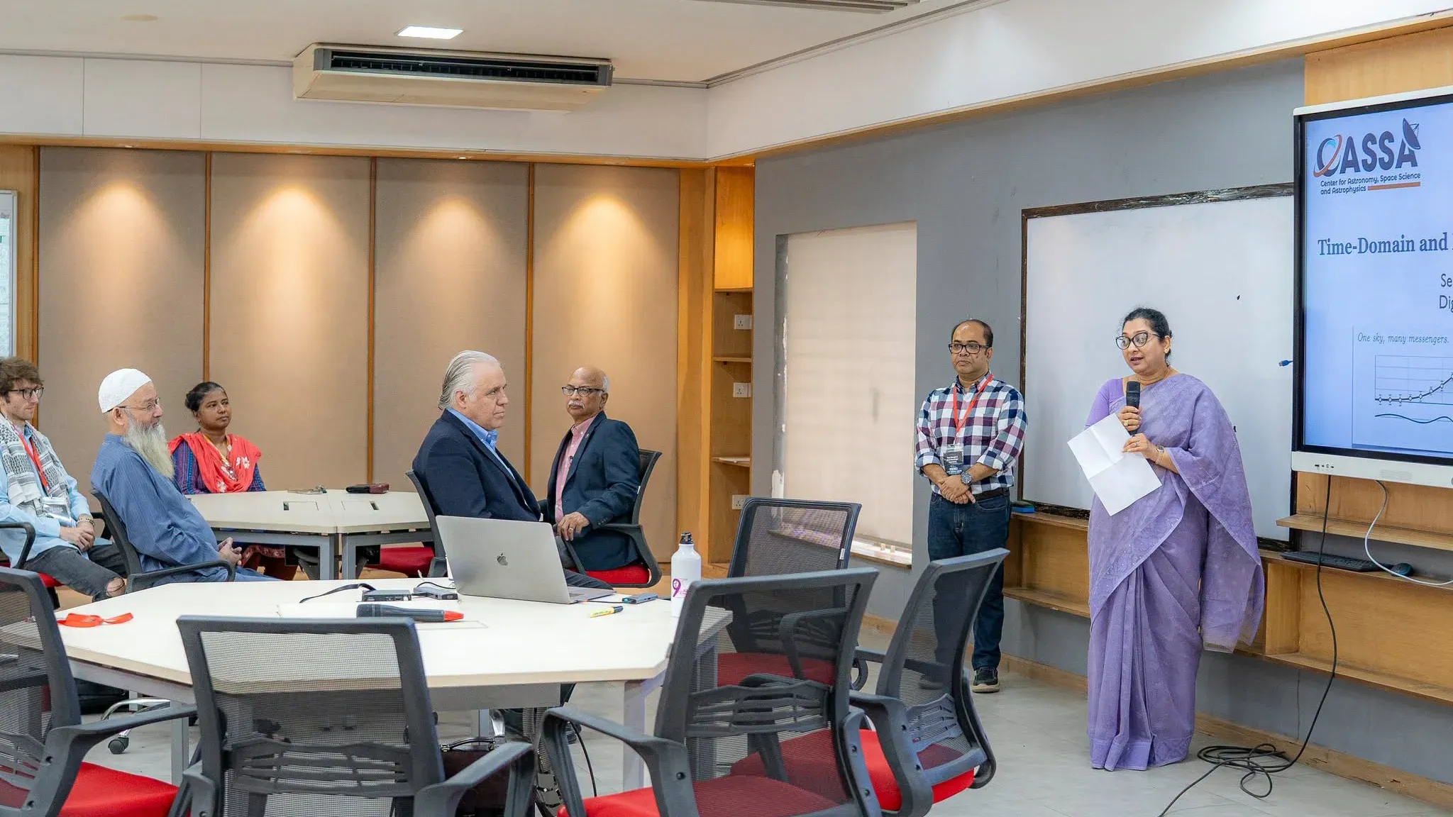 Dr. Rifat Ara Rouf, Head of the Department of Physical Sciences, speaks from notes at the front of the Digital Classroom.