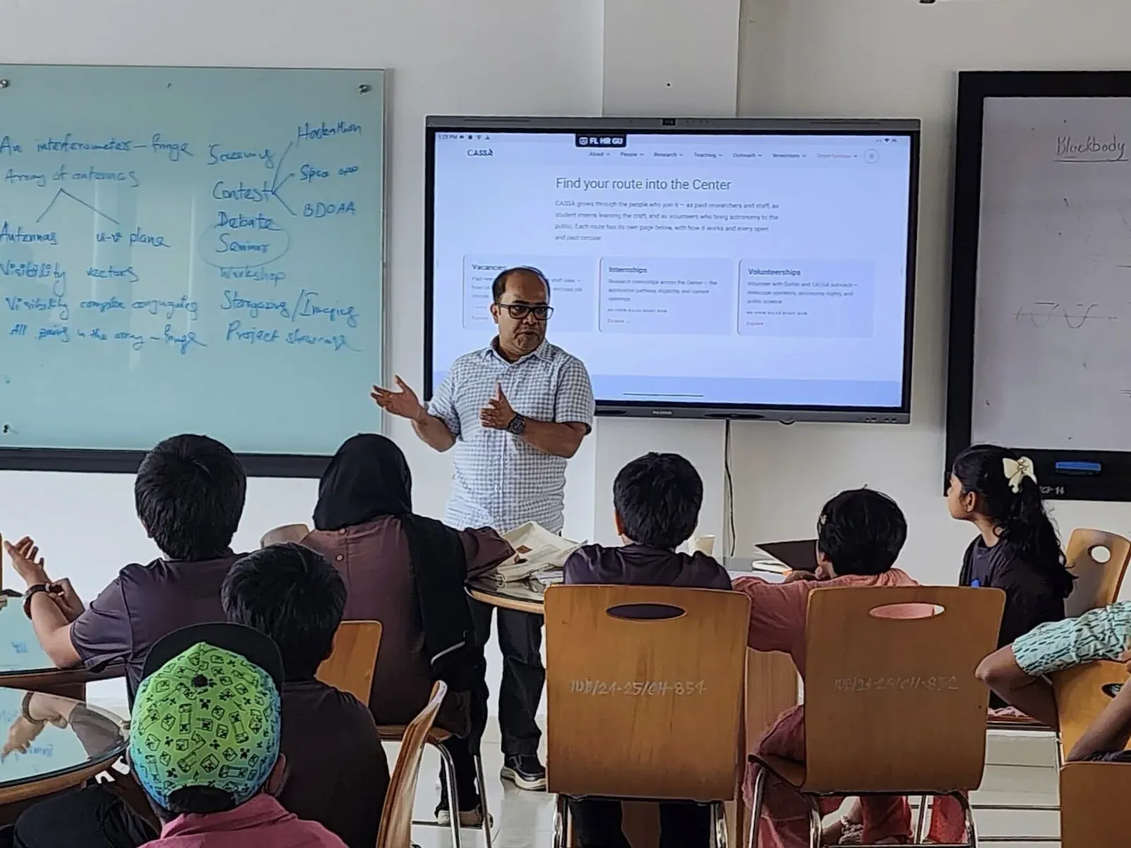 Dr. Syed Ashraf Uddin presents CASSA's opportunities page to seated students and guardians.